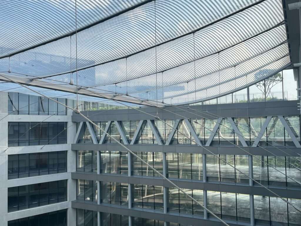 ETFE Singapore: Surbana Jurong Campus features cable-supported ETFE atrium roofs that deliver daylight, comfort, and energy efficiency in two indoor garden courtyards.